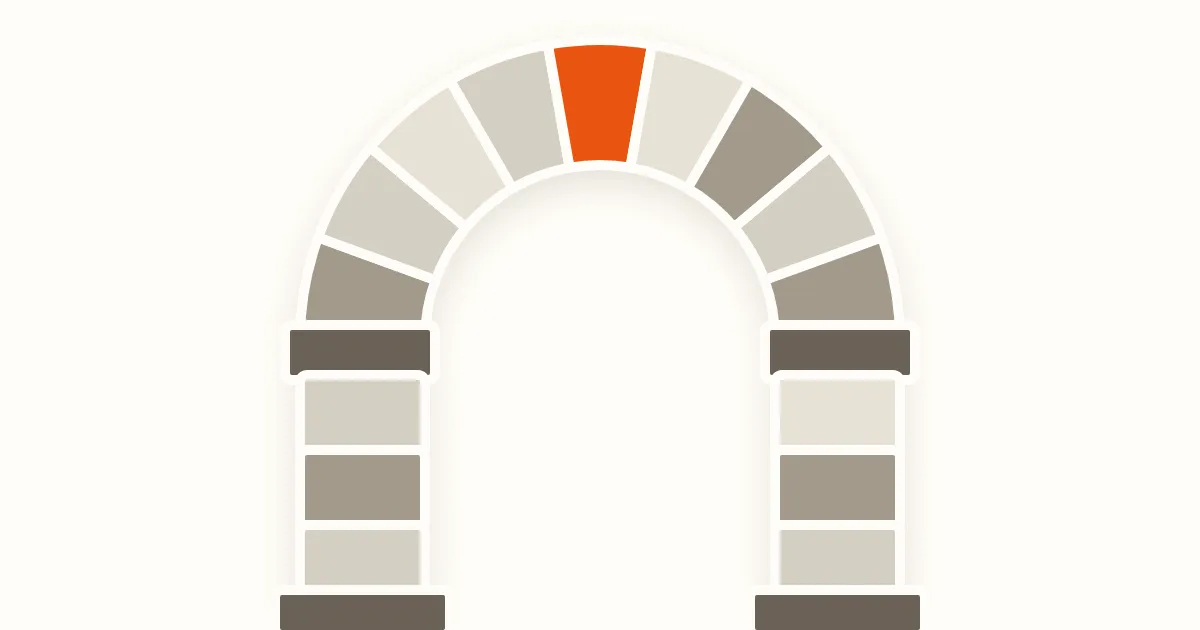 A segmented stone arch in warm beige and taupe, with an orange keystone at the crown and block pillars on both sides